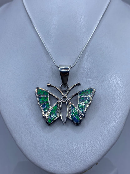 Detalle del ópalo de fuego azul con reflejos verdes en el dije mariposa de Taxco