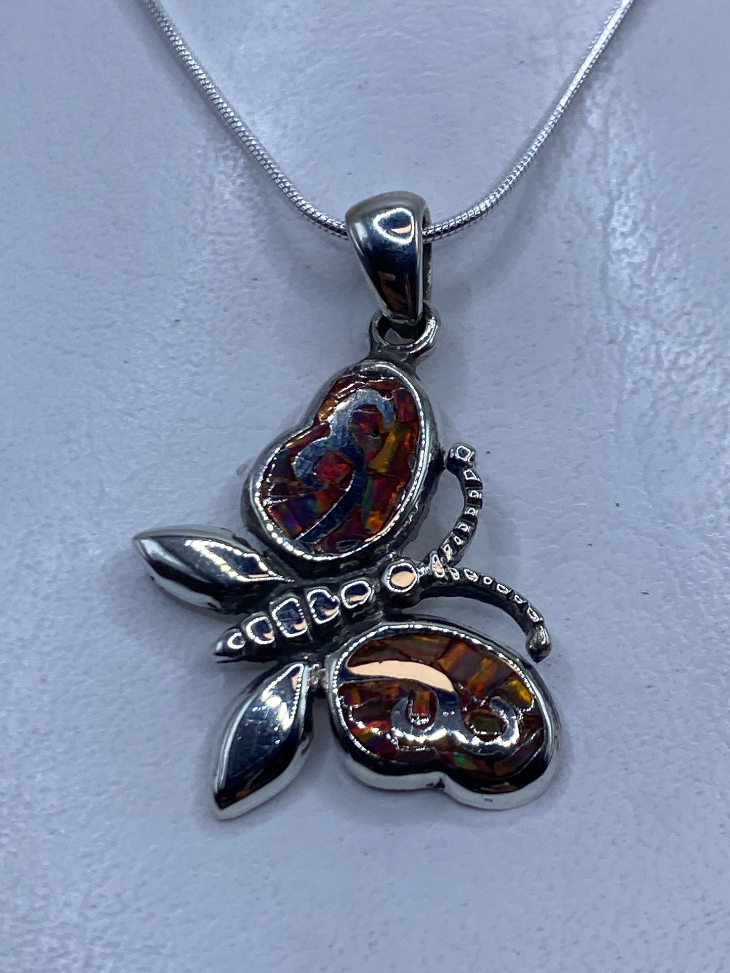 Dije de plata con ópalo de fuego multicolor en forma de maripota, incluye cadena de plata .950