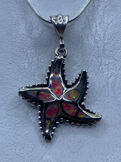 Dije estrella de mar en plata .950 con ópalo de fuego rosa, colgado en cadena de serpentina