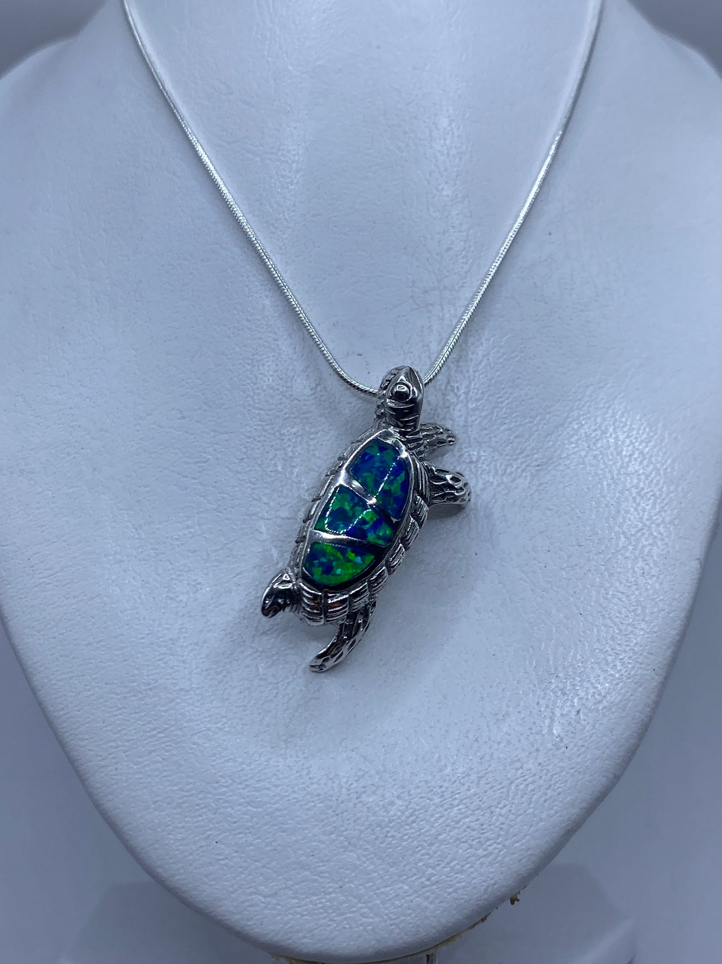 Medición del dije tortuga: 4.1 cm de largo sobre regla de centímetros
