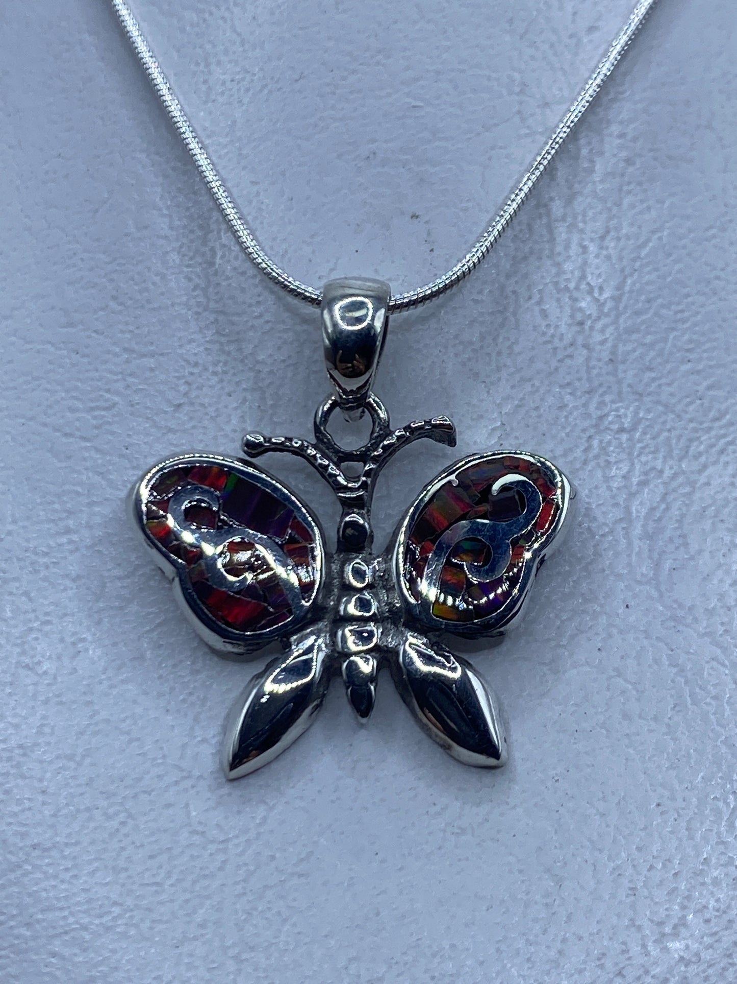 Dije mariposa de plata .950 con Ópalo de Fuego multicolor colgando de una cadena de plata