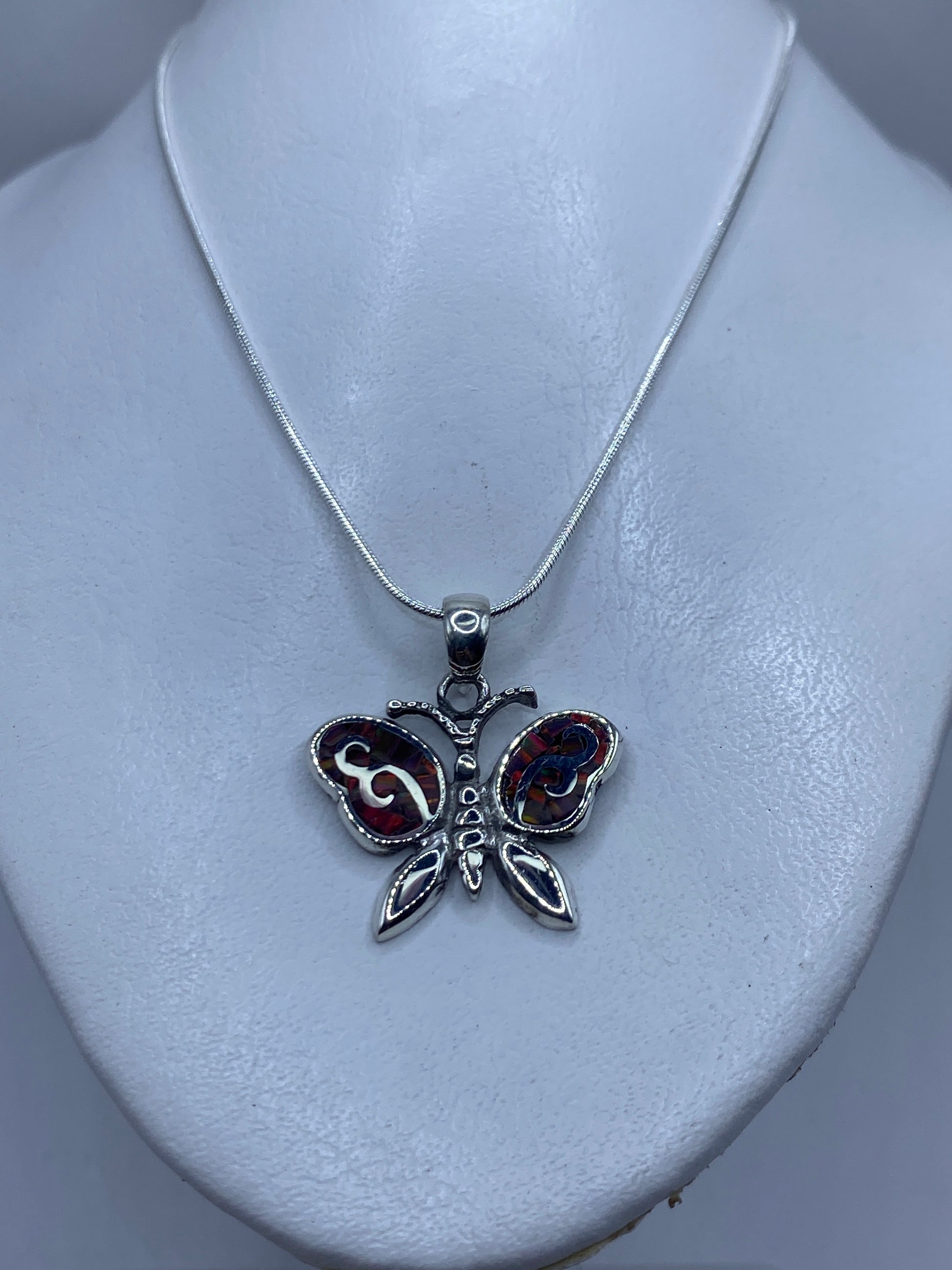 Detalle del Ópalo de Fuego multicolor en el dije mariposa de Taxco