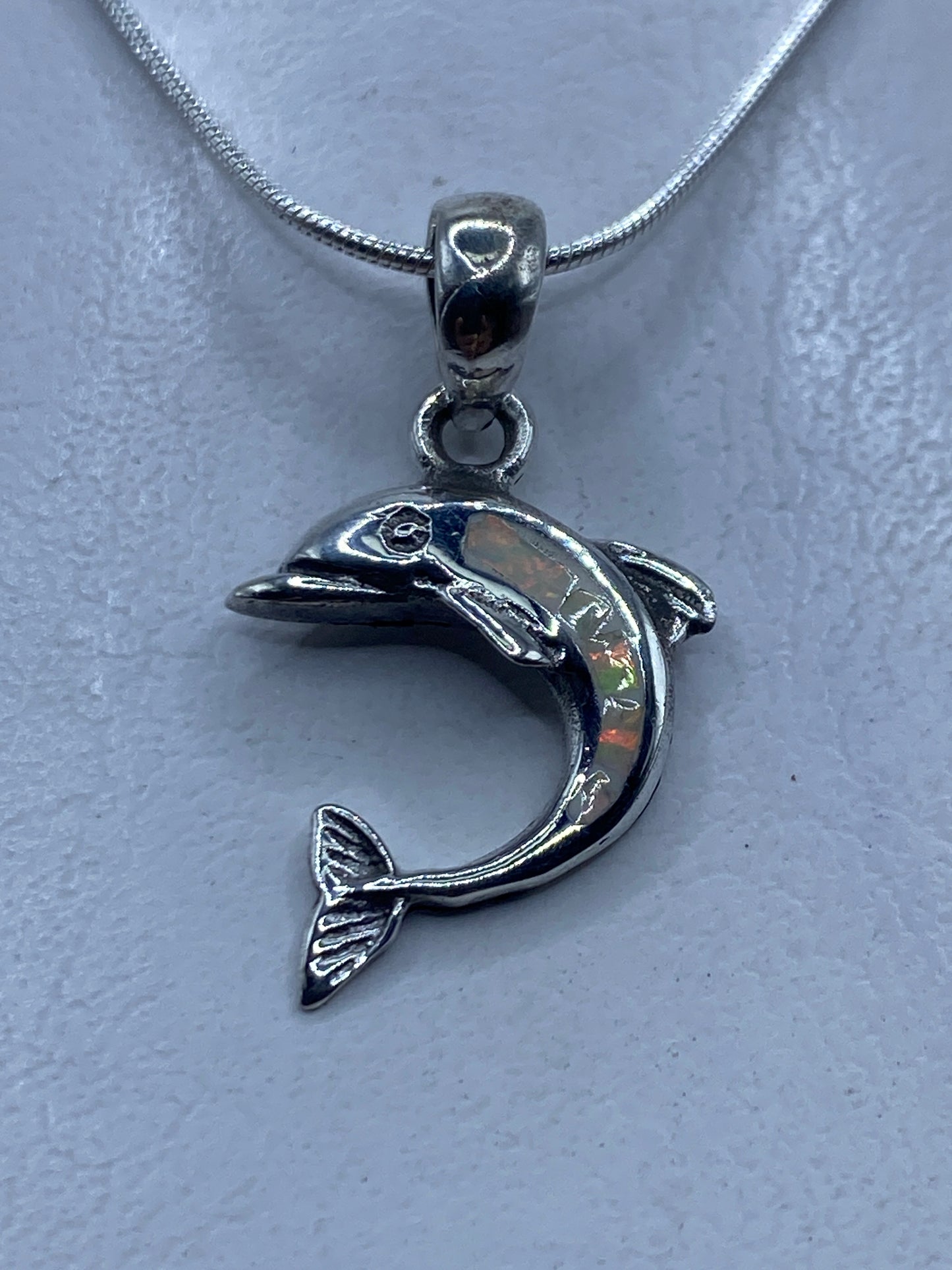 Dije de delfín en plata .950 con ópalo de fuego multicolor, colgando de una cadena de plata