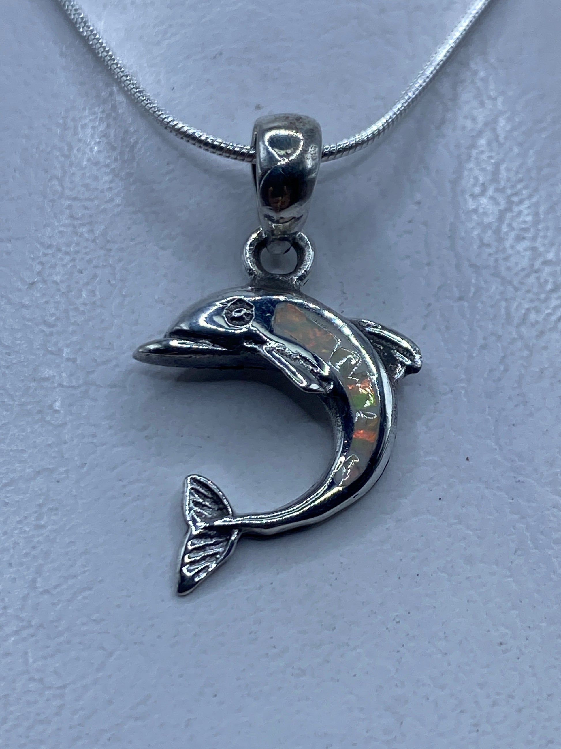 Dije de delfín en plata .950 con ópalo de fuego multicolor, colgando de una cadena de plata