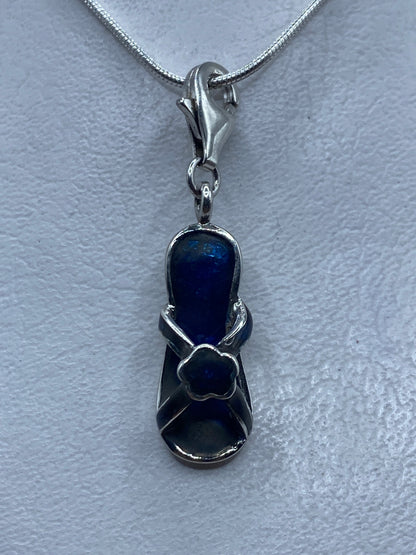 Dije de plata .925 con piedra azul engastada, colgando de cadena plateada