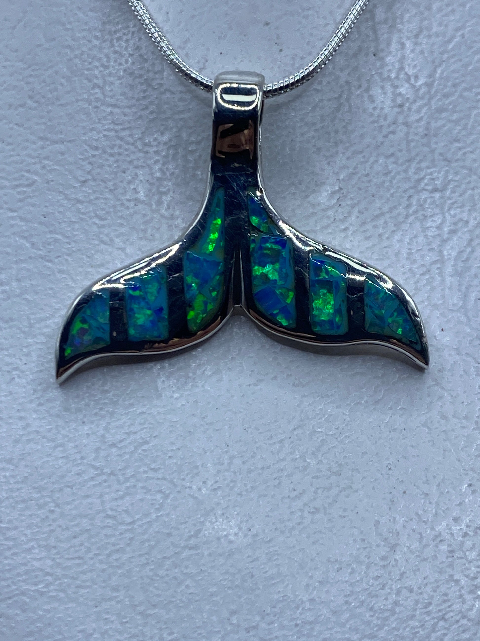 Dije de plata en forma de cola de ballena con ópalo de fuego azul cielo, colgando de cadena de plata