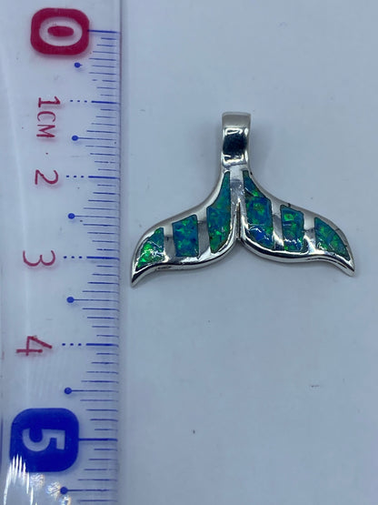 Medida del dije de 3.6 cm de largo junto a regla métrica