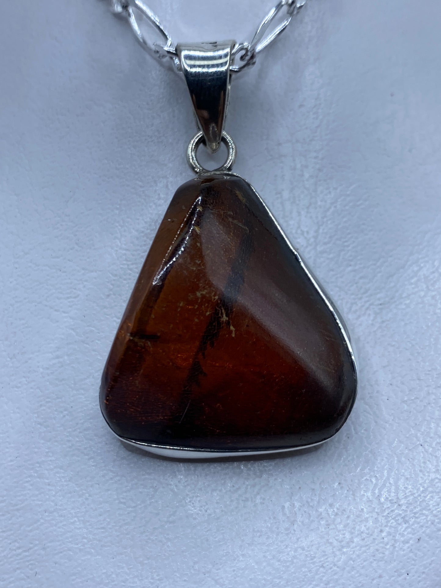 Dije de plata con ámbar natural engastado, colgando en cadena Figaro