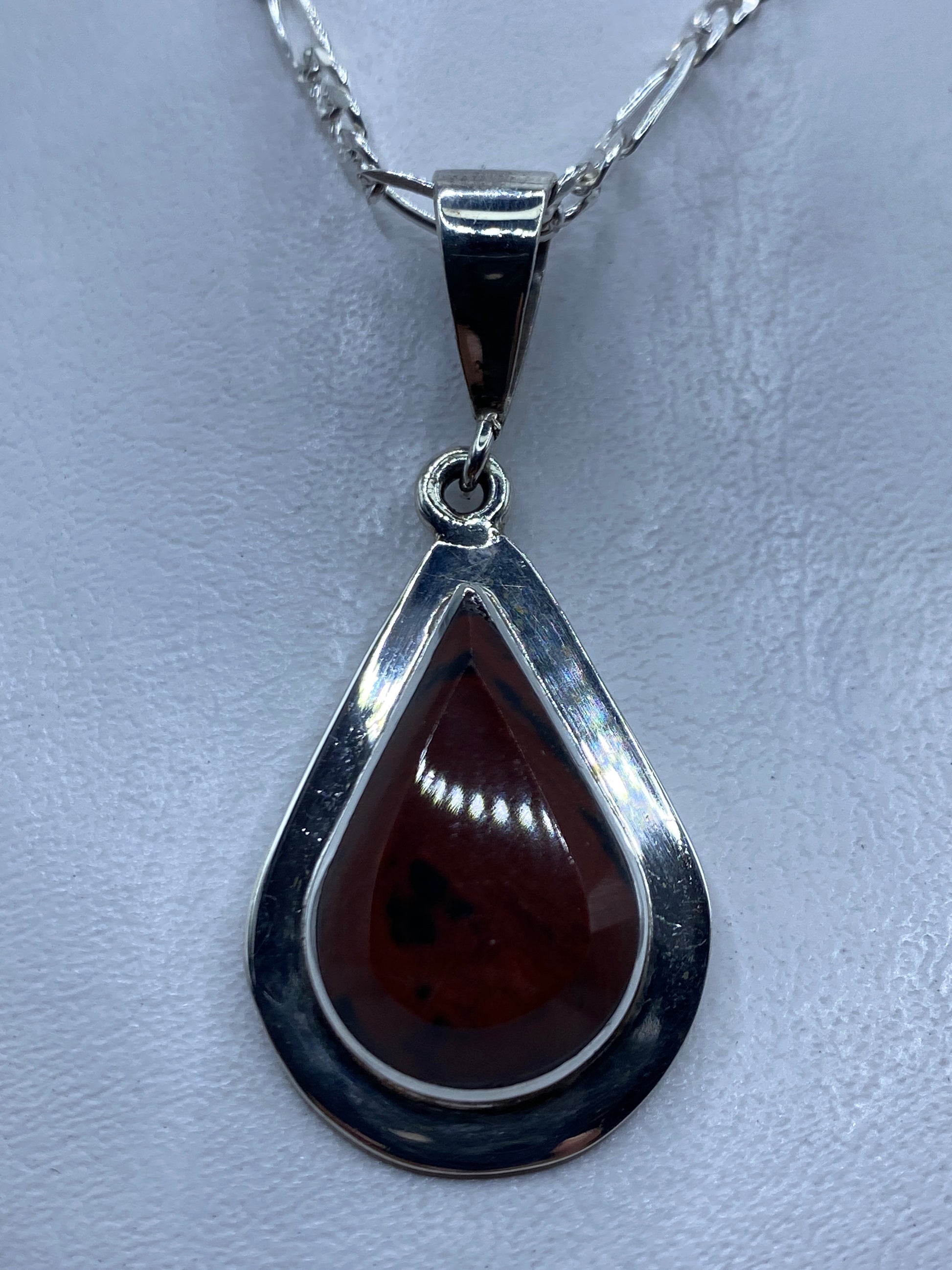 Dije de plata .950 con piedra café en forma de gota, colgado en cadena de plata