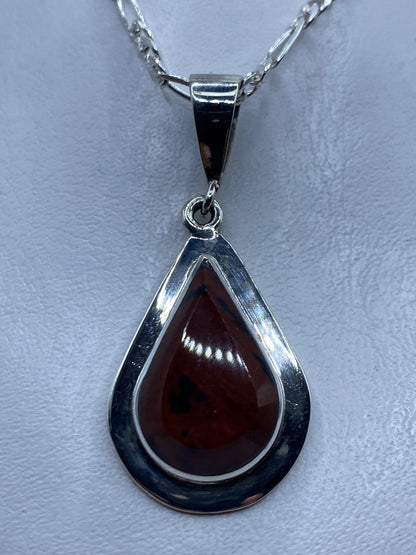 Dije de plata .950 con piedra café en forma de gota, colgado en cadena de plata