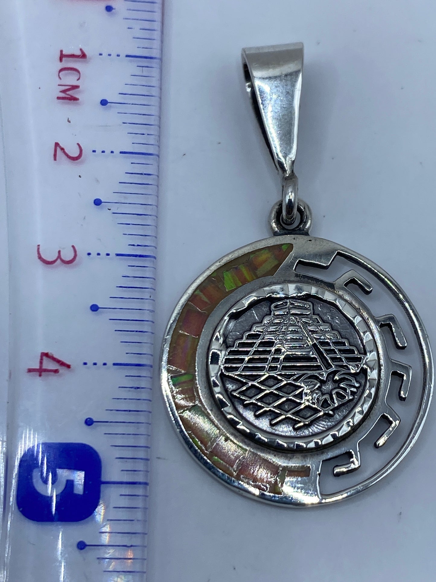 Dije de 5.2 cm de largo sostenido en la mano, escala real de tamaño
