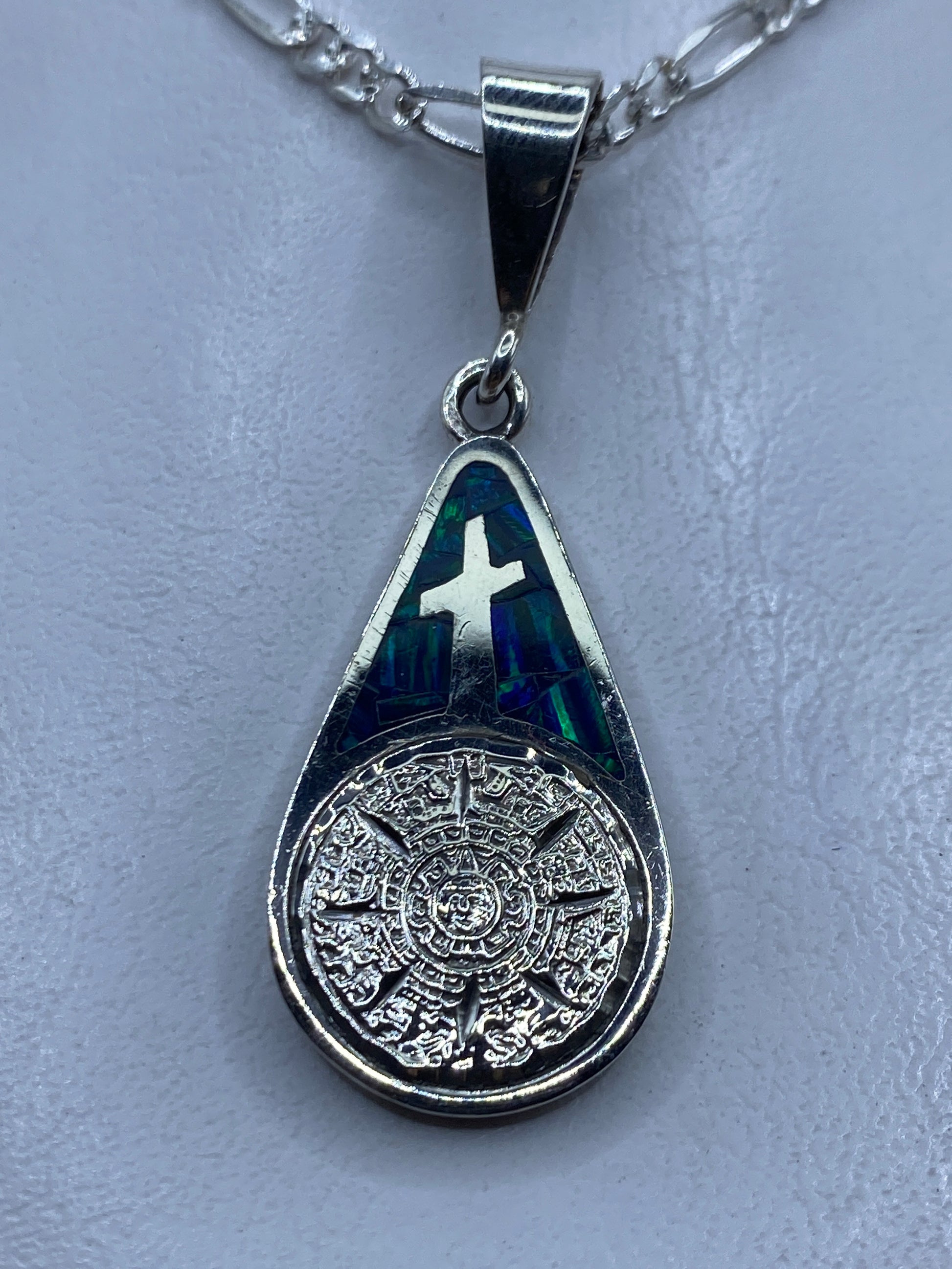 Dije de plata .950 con cruz religiosa y Ópalo de Fuego azul engastados, colgando en cadena de plata pulida
