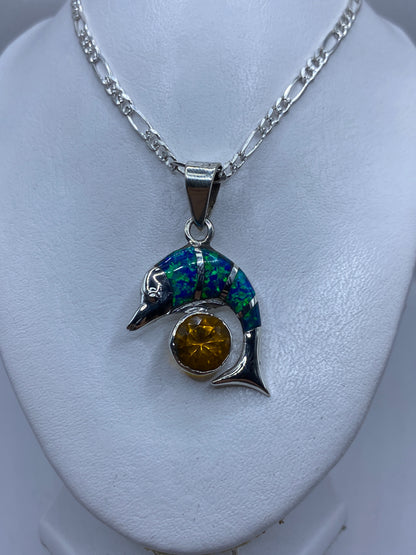 Dije de forma orgánica con cabeza de pájaro en plata y opalo de fuego