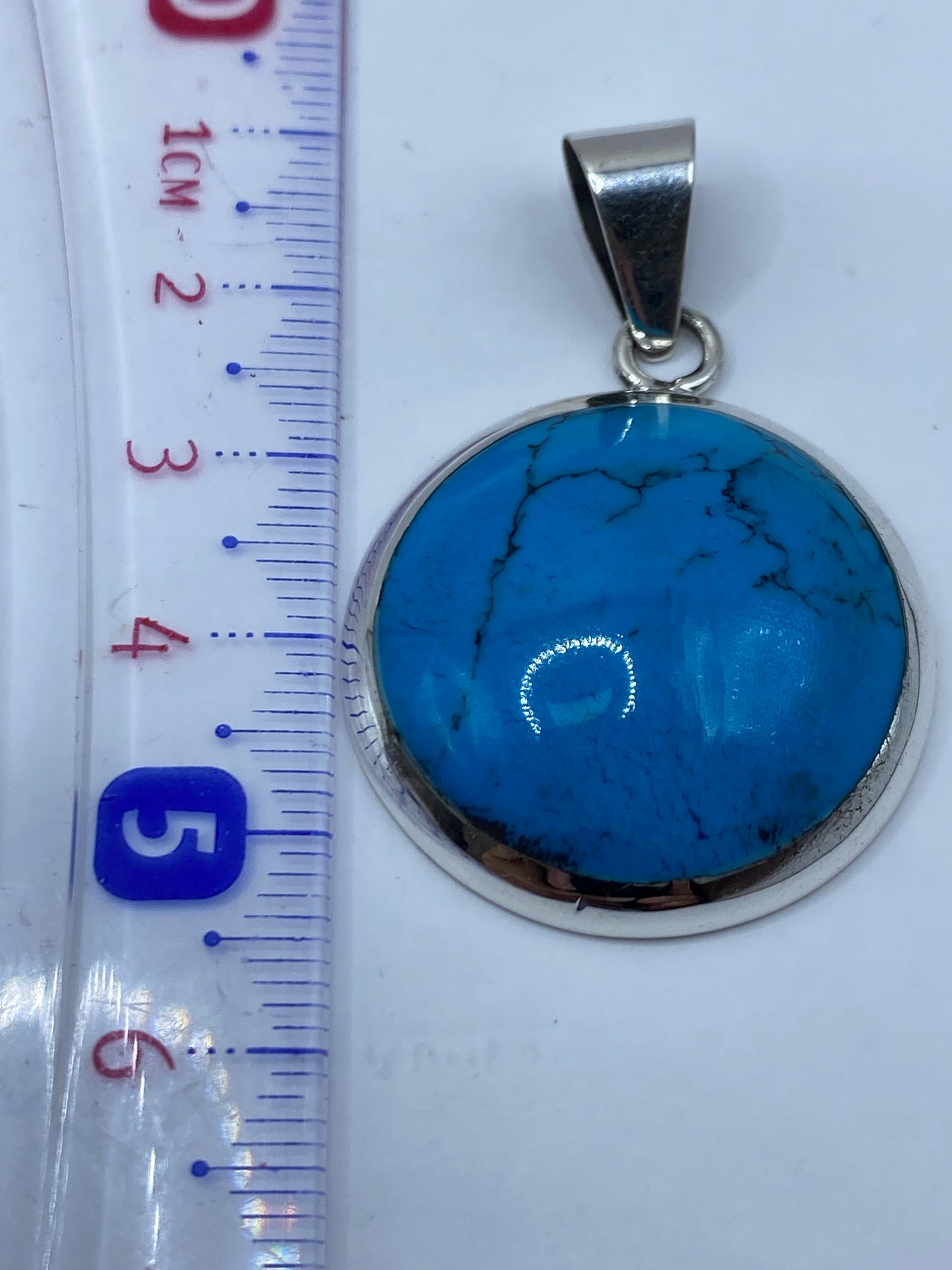 Reverso del dije en plata .950 mostrando el Quinto de autenticidad
