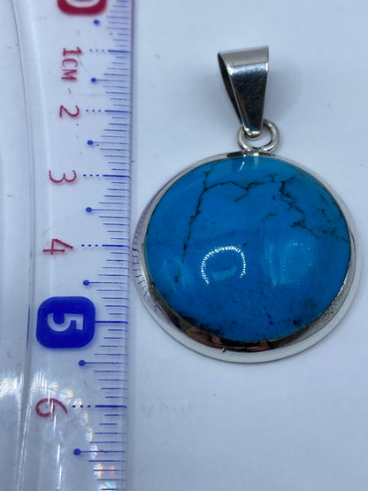 Reverso del dije en plata .950 mostrando el Quinto de autenticidad