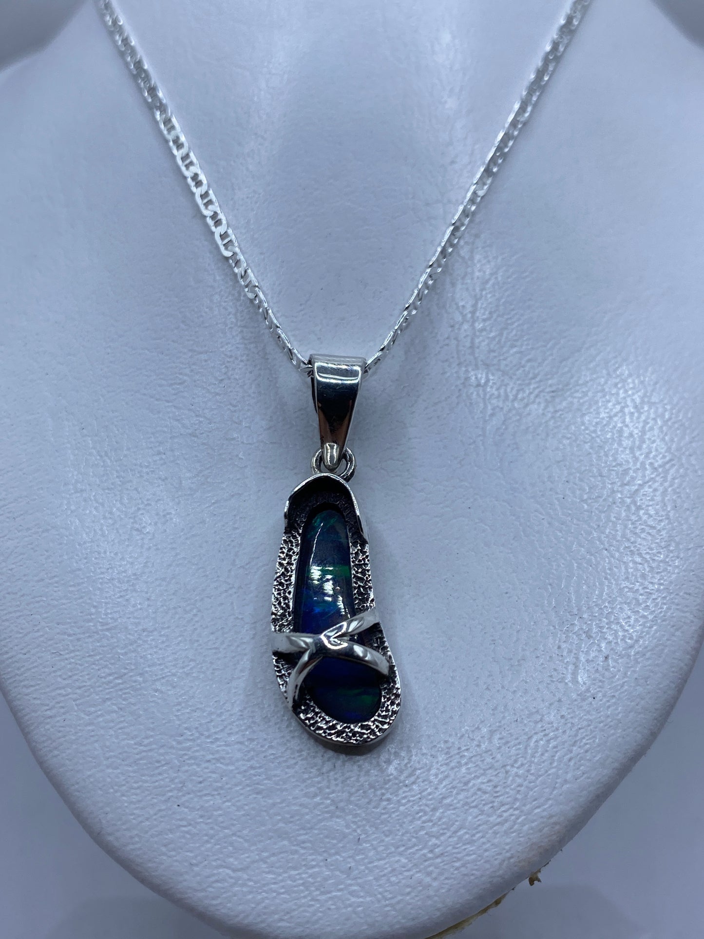 Ópalo de fuego azul con reflejos verdes y turquesas en la piedra, detalle de luz