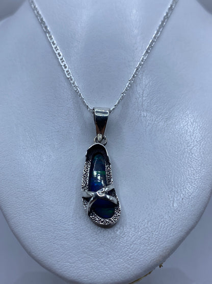 Ópalo de fuego azul con reflejos verdes y turquesas en la piedra, detalle de luz
