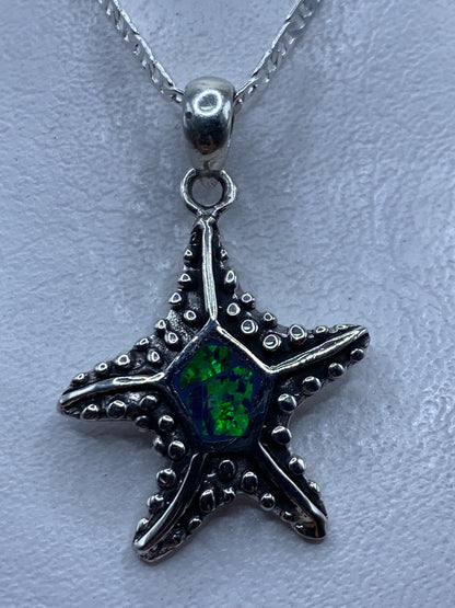 Dije estrella marina en plata .950 con ópalo de fuego multicolor engastado en el centro