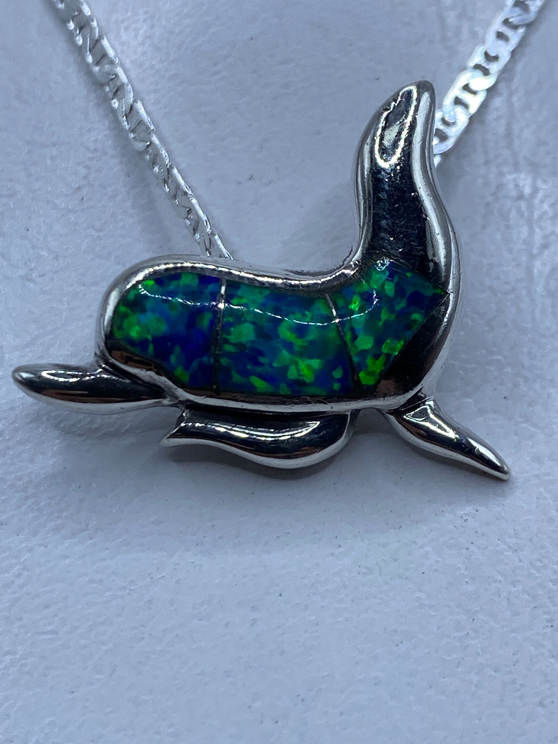 Dije delfín en plata .925 con ópalo de fuego azul, colgante de una cadena plateada