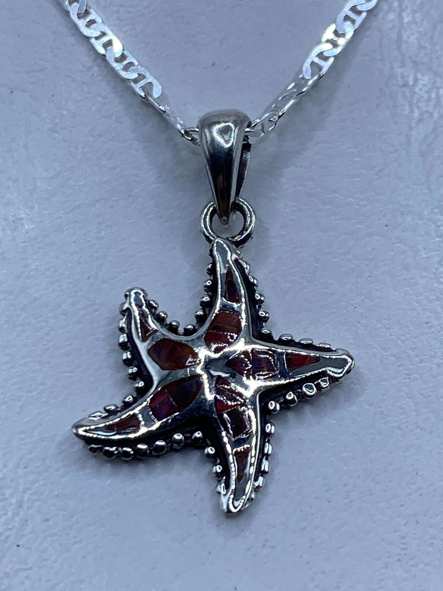 Dije estrella de mar en plata .950 con ópalo de fuego multicolor, colgando de cadena