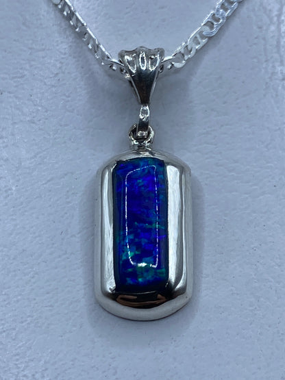 Dije de plata con ópalo de fuego azul colgando de cadena plateada