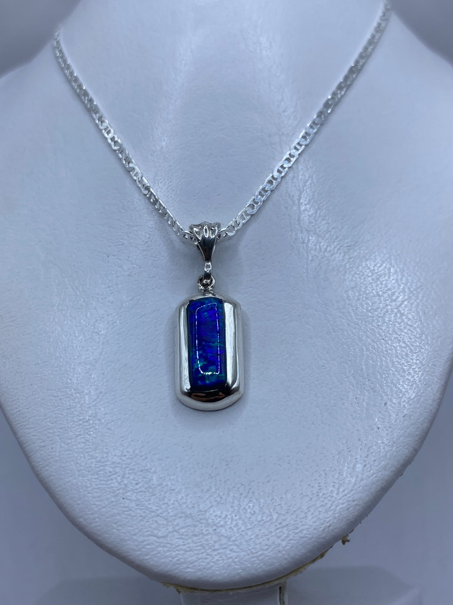 Primer plano del dije mostrando el ópalo azul engastado en plata .925