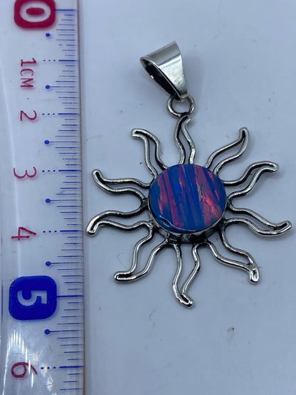 Dije sol sobre fondo neutro mostrando el sello de plata .950 en la parte posterior