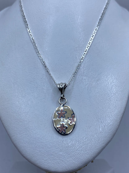 Dije de flores de 3.7 cm mostrado en modelo — discreto y elegante
