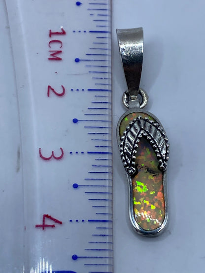 Medición del dije de 4.1 cm en regla milimétrica, con sello de autenticidad visible