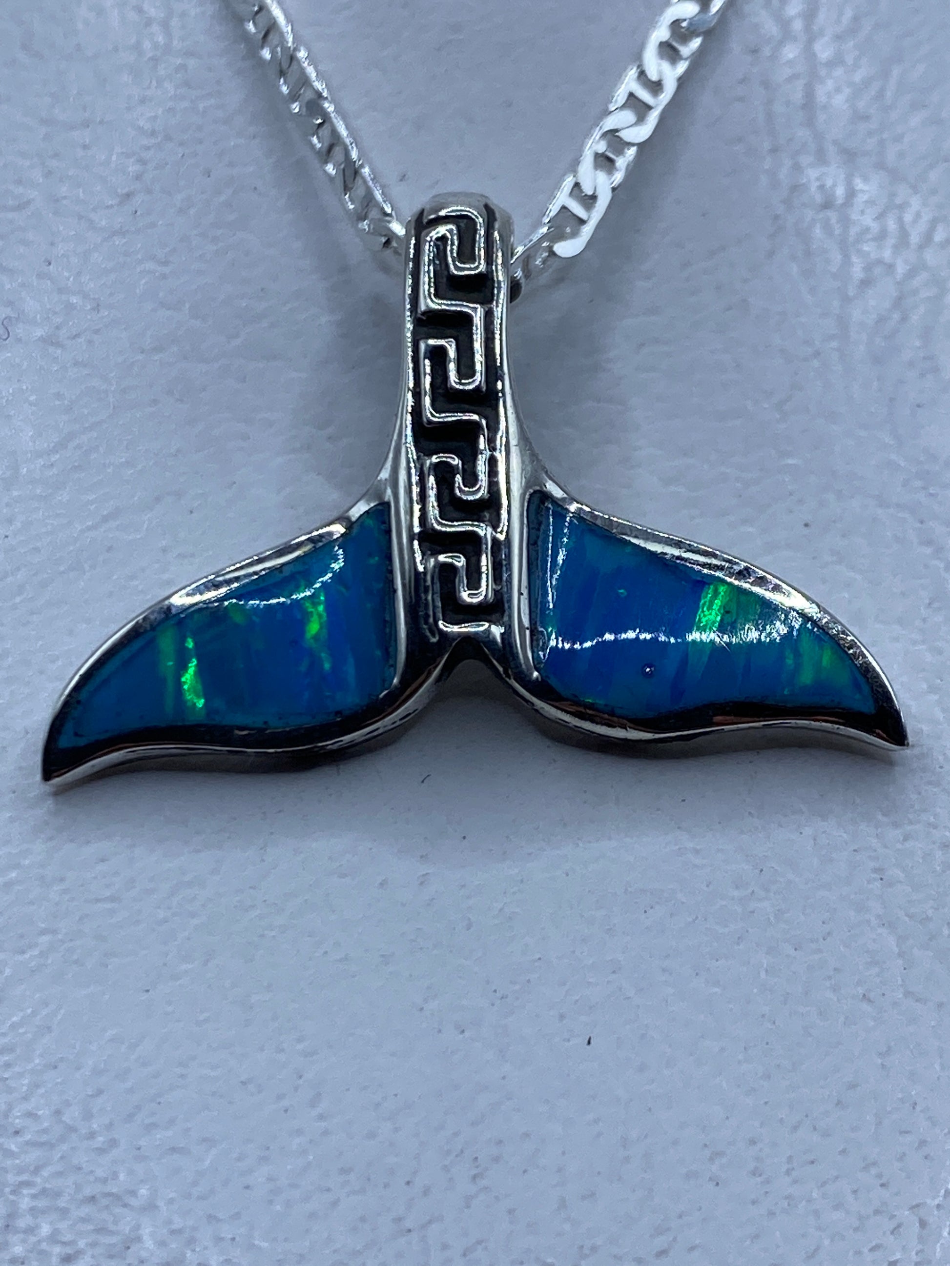 Dije de plata .950 en forma de cola de ballena con ópalo de fuego azul cielo, sobre cadena plateada
