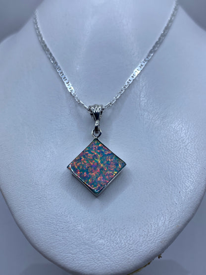 Dije cuadrado de plata con Ópalo de Fuego multicolor sobre piel, con cadena de eslabones gruesos
