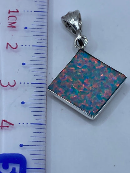 Dije de plata con Ópalo de Fuego sobre regla de centímetros, midiendo 3.3 cm de largo