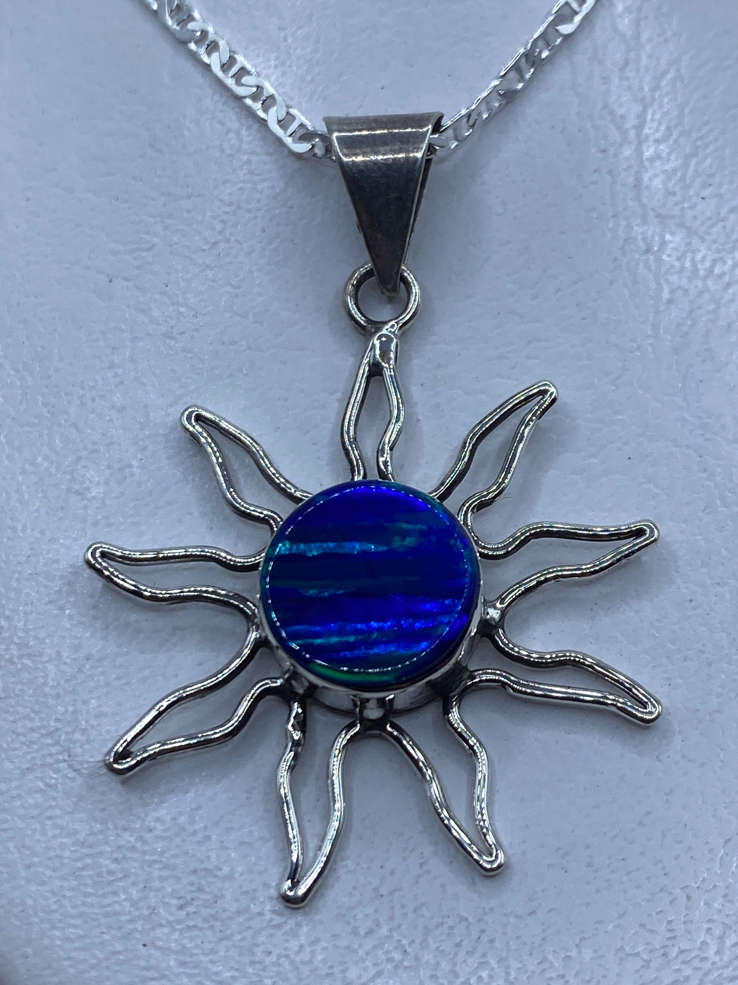 Dije sol de plata .950 con opalo de fuego azul en el centro, rayos de plata trabajada a mano