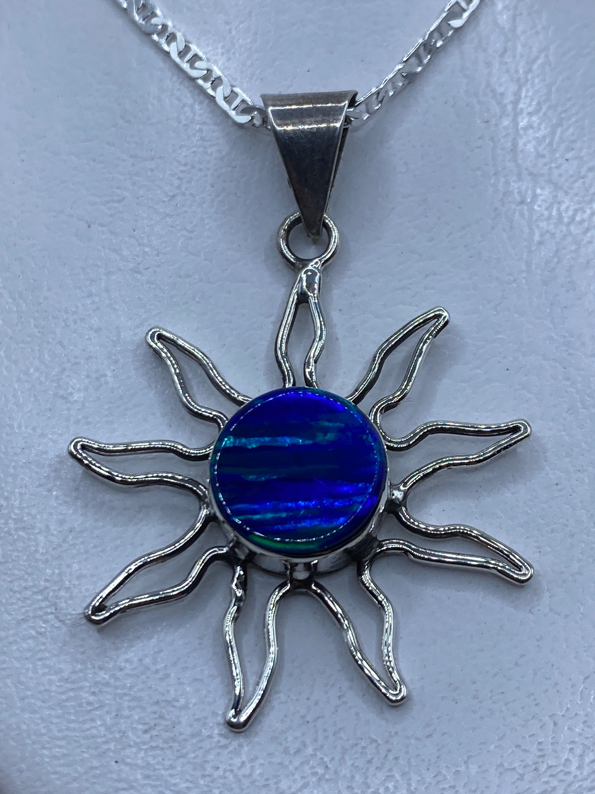 Dije sol de plata .950 con opalo de fuego azul en el centro, rayos de plata trabajada a mano