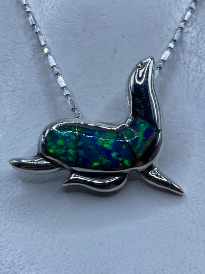 Dije de foca en plata .925 con ópalo de fuego azul, colgando de cadena de eslabón en plata