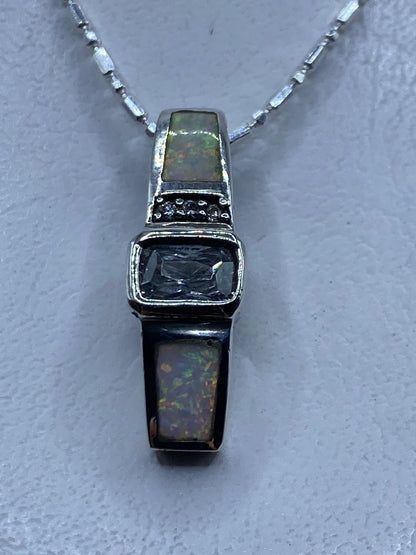 Dije de plata con ópalo de fuego multicolor colgando de cadena plateada