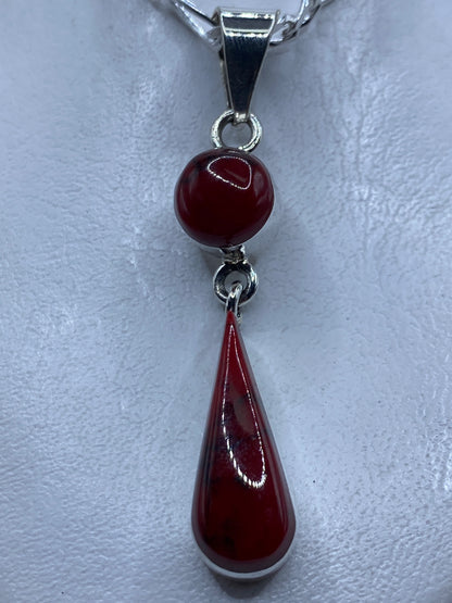 Dije de plata con coral rojo engastado, largo 6.3 cm, colgando de cadena plateada