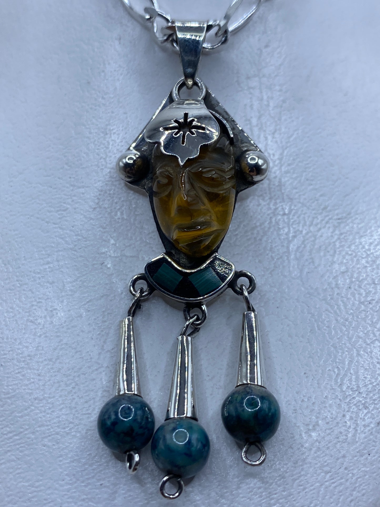 Dije de plata con rostro étnico tallado y piedra verde incrustada en la frente, largo 6.7 cm