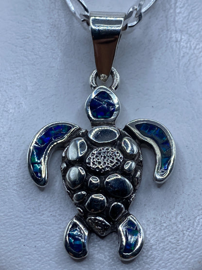 Dije tortuga en plata .950 con ópalo de fuego azul profundo, vista frontal