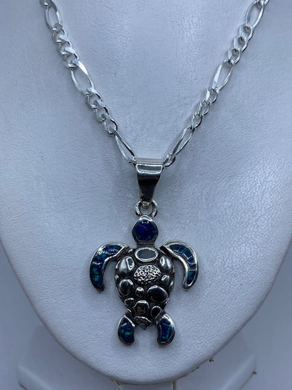 Dije tortuga de 5.3 cm sobre regla, detalle del engaste artesanal de ópalo