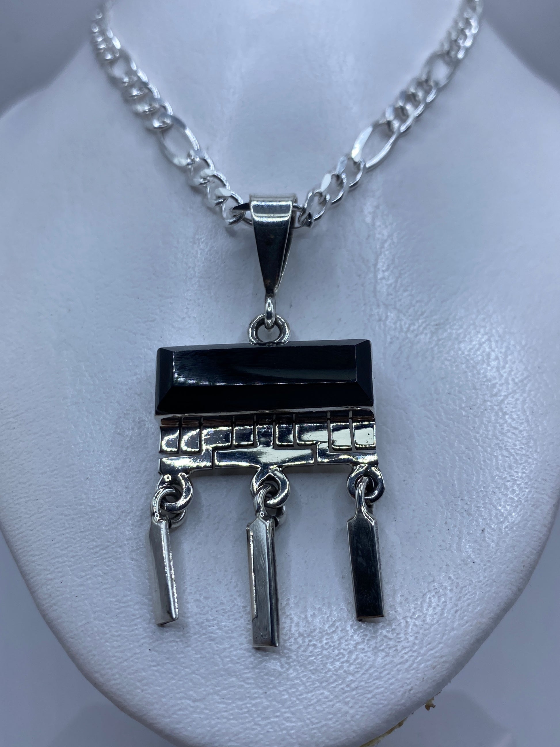 Detalle frontal del ónix negro pulido y el engaste de plata .950 a mano