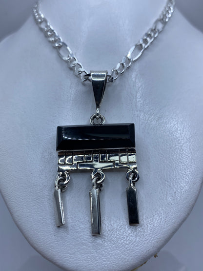 Detalle frontal del ónix negro pulido y el engaste de plata .950 a mano