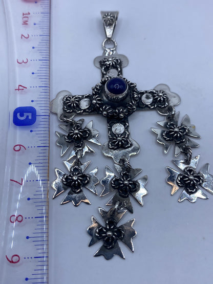 Dije cruz de 9.2 cm sobre escala de medidas, mostrando tamaño real sin cadena