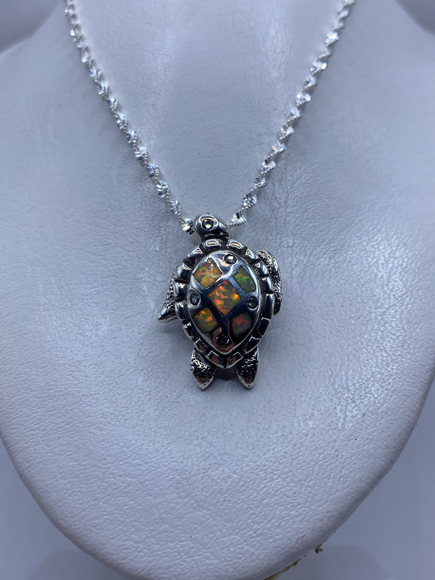 Dije tortuga visto de cerca mostrando el engaste de la piedra a mano