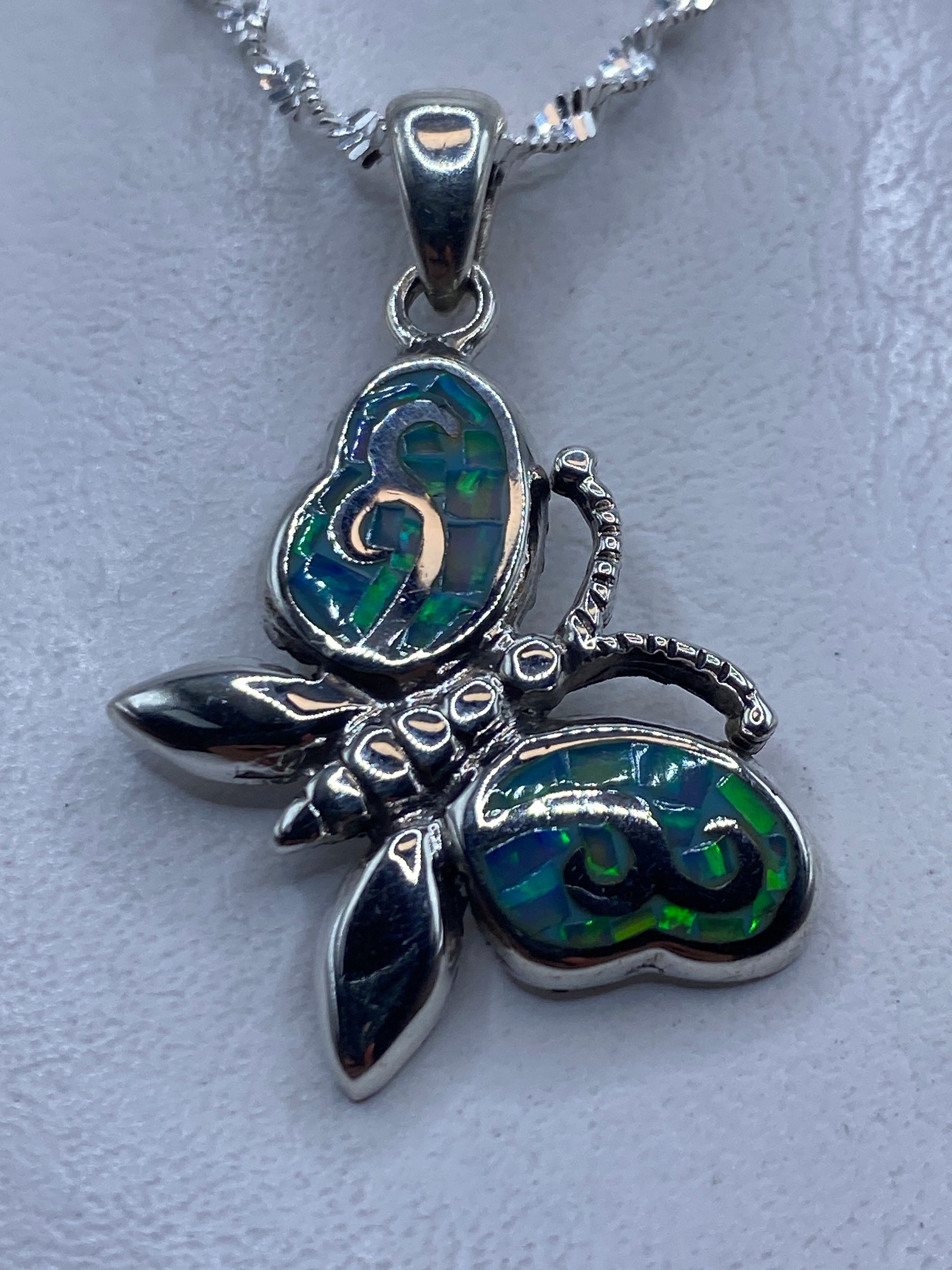 Dije de mariposa en plata .950 con ópalo de fuego azul cielo, colgado en cadena de plata