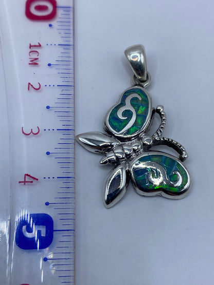 Medición del dije mariposa con regla: 4.5 cm de largo, pieza compacta y elegante