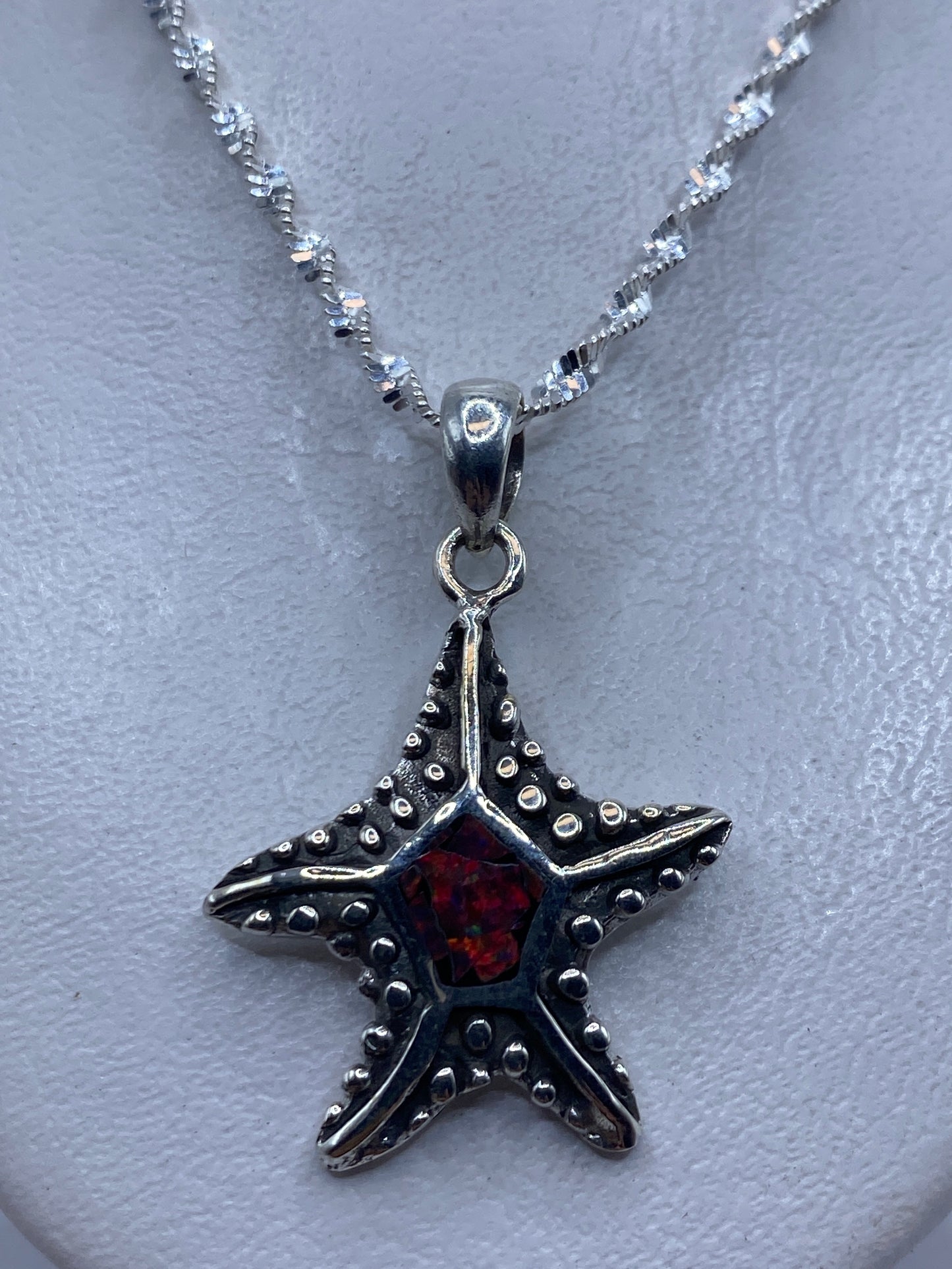 Dije estrella de mar de plata .950 con opalo de fuego multicolor en una cadena plateada