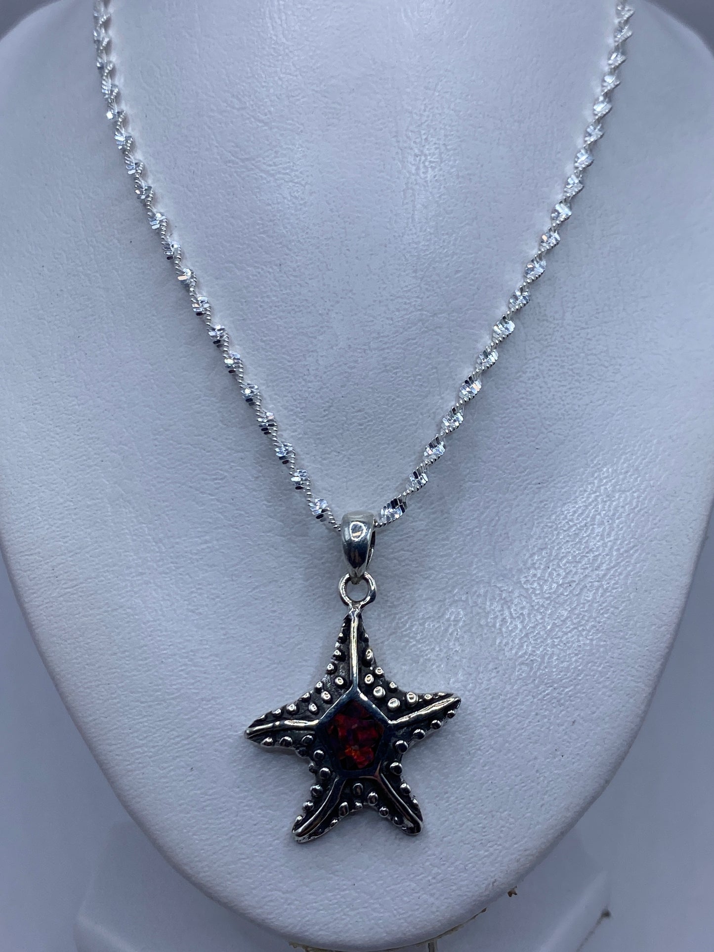 Detalle del reverso de la estrella de mar de plata con patrón de textura y el Quinto .950