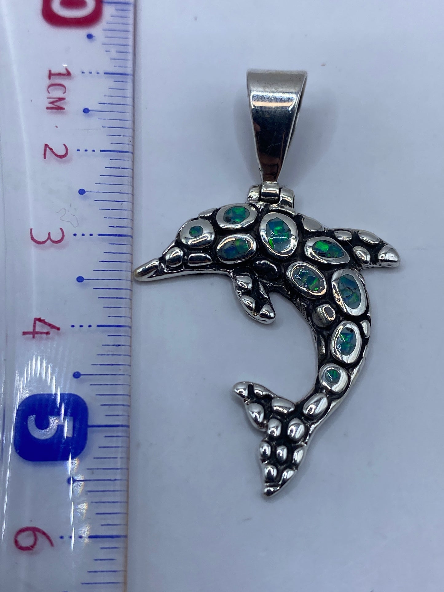 Dije delfín sobre regla: 6.5 cm de largo, peso 6 g, plata .950
