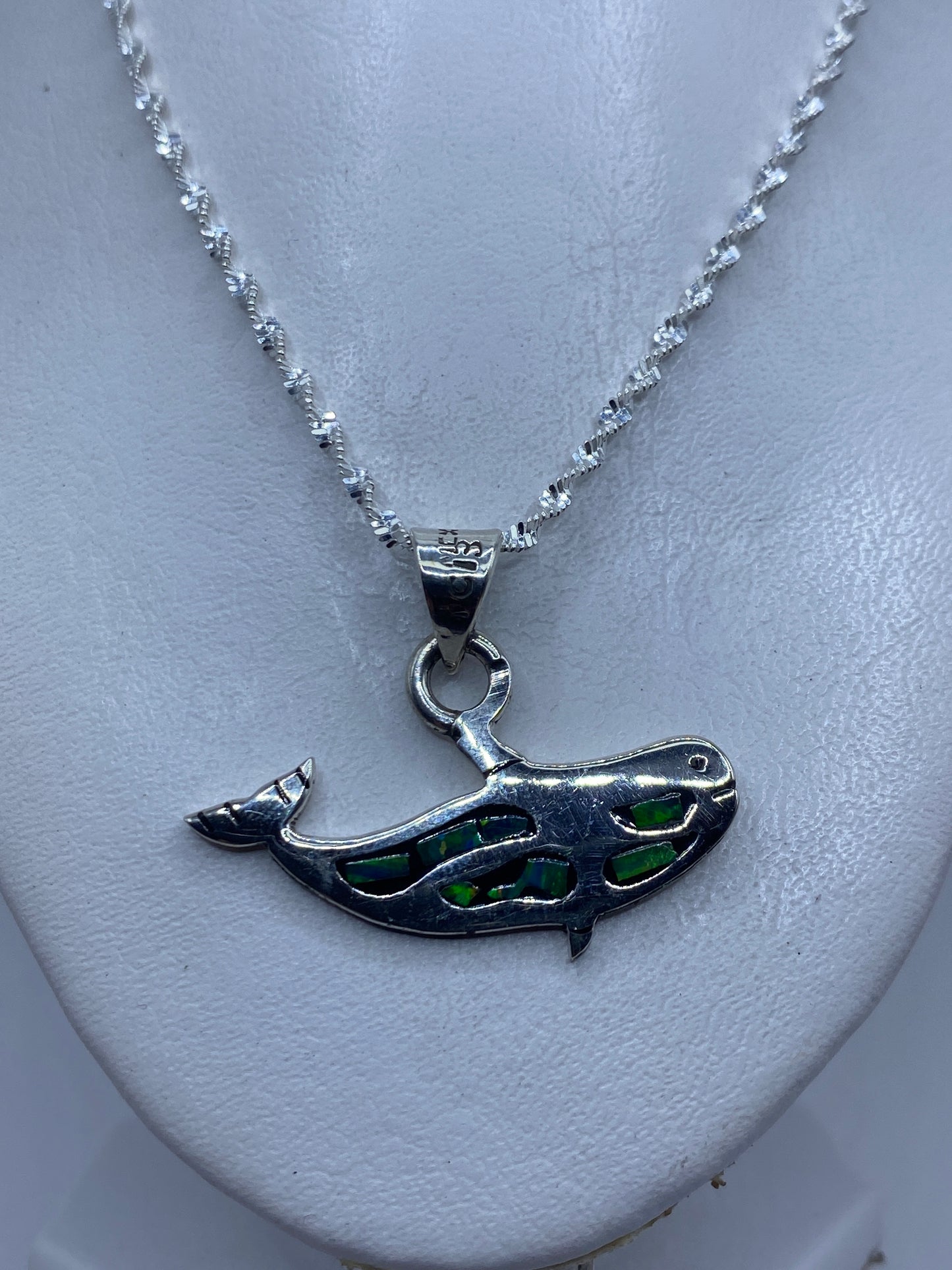 Dije de plata ópalo fuego mostrado sobre regla de medición: 3.7 cm de largo